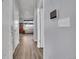 Hallway with hardwood floors and neutral paint, leading to a bedroom and a living area at 7888 Tejon St, Denver, CO 80221