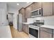 This kitchen boasts stainless steel appliances, white subway tile backsplash, and light wood floors at 7888 Tejon St, Denver, CO 80221