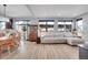Spacious living room featuring a sectional sofa, hardwood floors, large windows, and a dining set at 7888 Tejon St, Denver, CO 80221