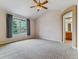 Large bedroom featuring plush carpet, a ceiling fan, and natural light from a large window at 1185 S Kramer Ct, Aurora, CO 80012