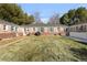 Brick home featuring a well-kept lawn and mature trees, offering a private outdoor living space at 1279 Leyden St, Denver, CO 80220