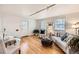Bright living room with hardwood floors, neutral furnishings, and a dining area with a glass-top table at 1279 Leyden St, Denver, CO 80220