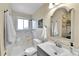 Bathroom with white marbled tile shower, modern vanity with chrome faucet, and decorative mirror with vanity lights at 16025 E Warren Pl, Aurora, CO 80013