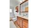 The bathroom features a tub, a shower, wood cabinets, and a bright mirror at 16025 E Warren Pl, Aurora, CO 80013
