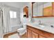 The bathroom features a tub, a shower, wood cabinets, and a bright mirror at 16025 E Warren Pl, Aurora, CO 80013