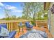 Deck with blue cushioned seating, side table, and a decorative rug, surrounded by foliage at 16025 E Warren Pl, Aurora, CO 80013