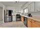 A bright kitchen features stainless steel appliances, ample counter space, and wood cabinets at 16025 E Warren Pl, Aurora, CO 80013