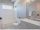 This bathroom features a shower over tub and modern vanity, all illuminated by the natural light from a window at 18155 Flowered Meadow Ln, Monument, CO 80132