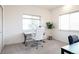 Bright office features carpet floors, natural light from two windows, a stylish desk and a comfortable white leather chair at 18155 Flowered Meadow Ln, Monument, CO 80132