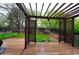 View of backyard from the wood deck, with wood pergola, manicured yard, patio seating, and fenced perimeter at 3565 W 112Th Cir, Westminster, CO 80031
