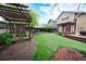 Backyard featuring lush green artificial grass, a wood deck with pergola, and stone patio at 3565 W 112Th Cir, Westminster, CO 80031