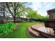 Spacious backyard featuring artificial grass, a wood pergola, patio seating, and tiered landscaping at 3565 W 112Th Cir, Westminster, CO 80031