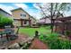 Large backyard featuring a wood pergola, patio seating, mature trees, and established landscaping at 3565 W 112Th Cir, Westminster, CO 80031