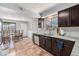 Bright kitchen with stainless steel appliances, granite countertops, dark cabinetry and tile floors at 120 Field St, Lakewood, CO 80226