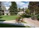 Charming apartment building with lush green lawn and mature trees providing shade at 675 S Clinton St # 8B, Denver, CO 80247