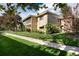 Tan apartment building featuring a screened-in porch and mature landscaping at 675 S Clinton St # 8B, Denver, CO 80247