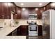 Updated kitchen featuring granite countertops, stainless steel appliances, and dark wood cabinets at 675 S Clinton St # 8B, Denver, CO 80247