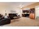 Cozy living room with dark brown leather furniture, carpeting, and a view of the kitchen at 675 S Clinton St # 8B, Denver, CO 80247