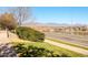Scenic street view featuring a neighborhood road, lush greenery, and mountain backdrop at 10149 W 55Th Dr # 3, Arvada, CO 80002
