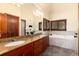 Bathroom with a double vanity, a soaking tub, and wood-framed windows at 4245 S Dawson St, Aurora, CO 80014
