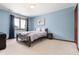 Cozy bedroom features carpet floors, blue walls, and a window with natural light at 4245 S Dawson St, Aurora, CO 80014