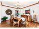 Formal dining room with hardwood floors, crown molding, chandelier, and a large window for natural light at 4245 S Dawson St, Aurora, CO 80014