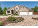 Beautiful tan brick home with a three car garage and a well manicured front yard and flower beds at 4245 S Dawson St, Aurora, CO 80014