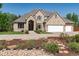 Beautiful tan brick home with a three car garage and a well manicured front yard and flower beds at 4245 S Dawson St, Aurora, CO 80014