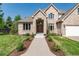 Attractive tan brick home with a three car garage, landscaped front yard, and a glass paneled front door at 4245 S Dawson St, Aurora, CO 80014