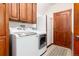 Well-equipped laundry room with wooden cabinets, a washer and dryer set, and a refrigerator at 4245 S Dawson St, Aurora, CO 80014