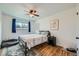 This well-lit bedroom offers a ceiling fan, a large window, and hardwood floors at 18662 E Brown Pl, Aurora, CO 80013