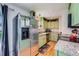 Cozy kitchen featuring updated stainless steel appliances, green cabinets, and bright countertops at 18662 E Brown Pl, Aurora, CO 80013
