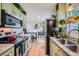 Bright kitchen features green cabinetry, stainless steel appliances, granite counters and wood-style flooring at 18662 E Brown Pl, Aurora, CO 80013