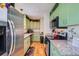 Functional kitchen with stainless steel appliances, green cabinetry, and ample counter space at 18662 E Brown Pl, Aurora, CO 80013