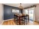 Charming dining area with a modern chandelier, 'gather' sign, and sliding glass doors to the backyard at 34241 E Columbine Trl, Elizabeth, CO 80107