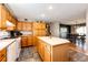 Open concept kitchen features a kitchen island, wood cabinets, and views to an adjacent dining area at 34241 E Columbine Trl, Elizabeth, CO 80107