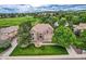 Aerial view of brick house, large front lawn, landscaping, and golf course community at 7758 Edgewater Ct, Lone Tree, CO 80124