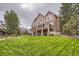 Beautiful backyard features a manicured lawn, mature trees, and landscaping at 7758 Edgewater Ct, Lone Tree, CO 80124