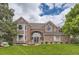 Charming two-story brick home with a well-manicured lawn and inviting front entrance at 7758 Edgewater Ct, Lone Tree, CO 80124