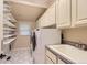Functional laundry room with ample storage cabinets, shelving, and modern washer and dryer units at 7758 Edgewater Ct, Lone Tree, CO 80124