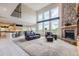 Open-concept floor plan with a grand living room featuring a brick fireplace and expansive windows at 7758 Edgewater Ct, Lone Tree, CO 80124