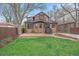 Inviting backyard with a well-manicured lawn, brick patio, and charming two-story brick house at 371 Birch St, Denver, CO 80220