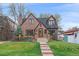 Beautiful brick home with a manicured lawn, stone walkway, and mature trees at 371 Birch St, Denver, CO 80220