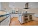Modern kitchen featuring white cabinets, black countertops, and a large kitchen island at 371 Birch St, Denver, CO 80220