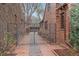 Brick pathway with a gated entry between the house and brick wall with climbing ivy at 371 Birch St, Denver, CO 80220