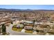 Expansive aerial view of a neighborhood with mountain views, mature trees, and well-maintained homes at 1667 S Balsam Ct, Lakewood, CO 80232