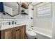 Bathroom features a unique mirror, white subway tile, black fixtures, and updated vanity at 1667 S Balsam Ct, Lakewood, CO 80232