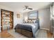 Cozy bedroom featuring a ceiling fan, wood floors, a window, and a built-in bookcase at 1667 S Balsam Ct, Lakewood, CO 80232