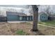 Exterior of the house with a covered patio connecting it to a detached garage and spacious backyard at 415 S Parfet St, Lakewood, CO 80226