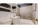 Bathroom featuring a tub, tiled walls, and a mirrored cabinet at 415 S Parfet St, Lakewood, CO 80226